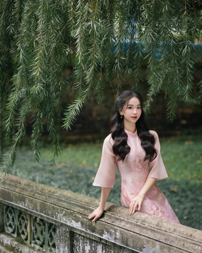 Nàng diện áo dài hồng ngồi bên lan can