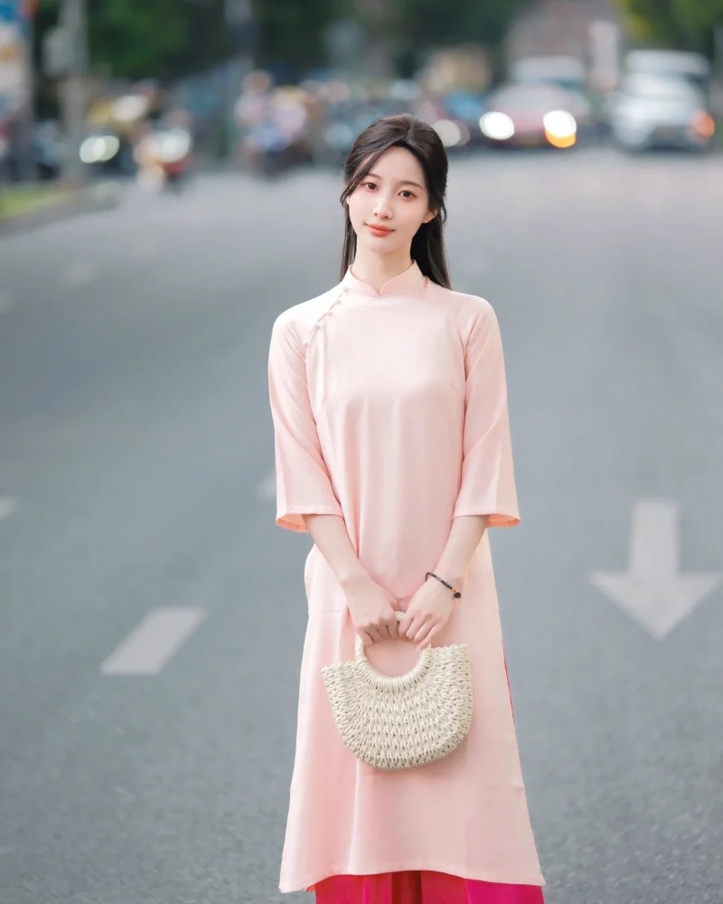 Người đẹp mặc áo dài pastel đứng giữa đường