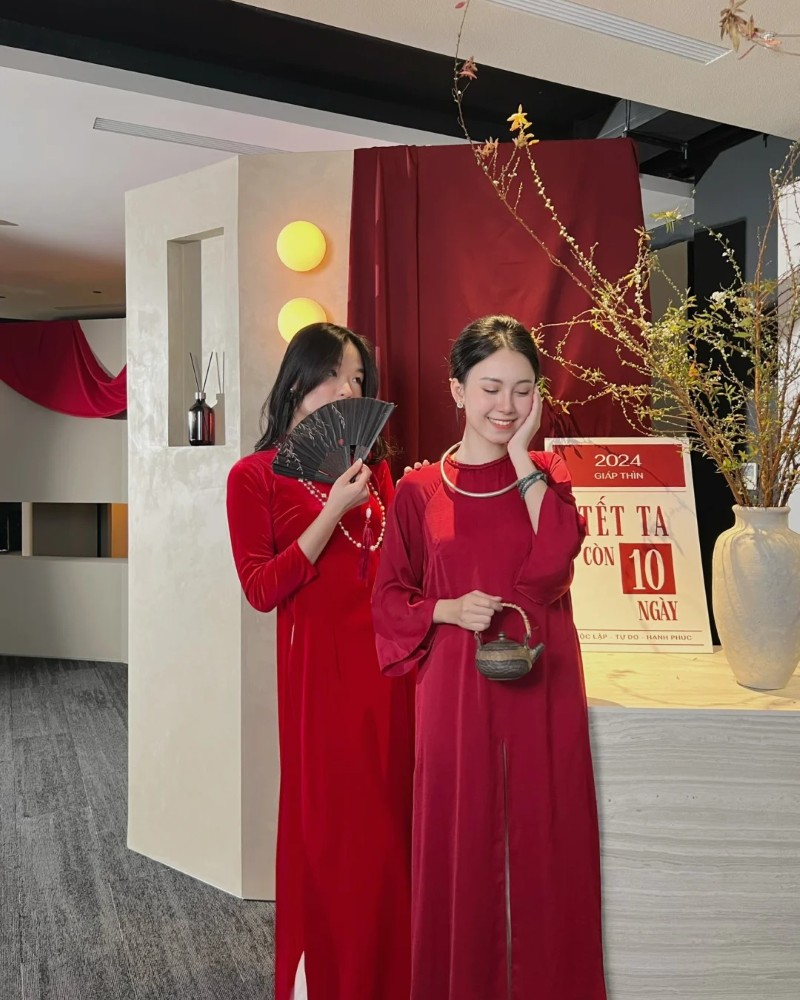 Hai người đẹp mặc áo dài đỏ chụp ảnh ngày lễ