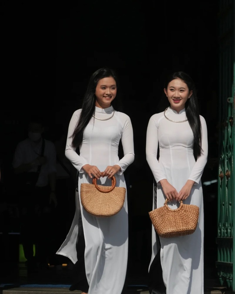 Hai cô gái mặc áo dài trắng tạo dáng truyền thống