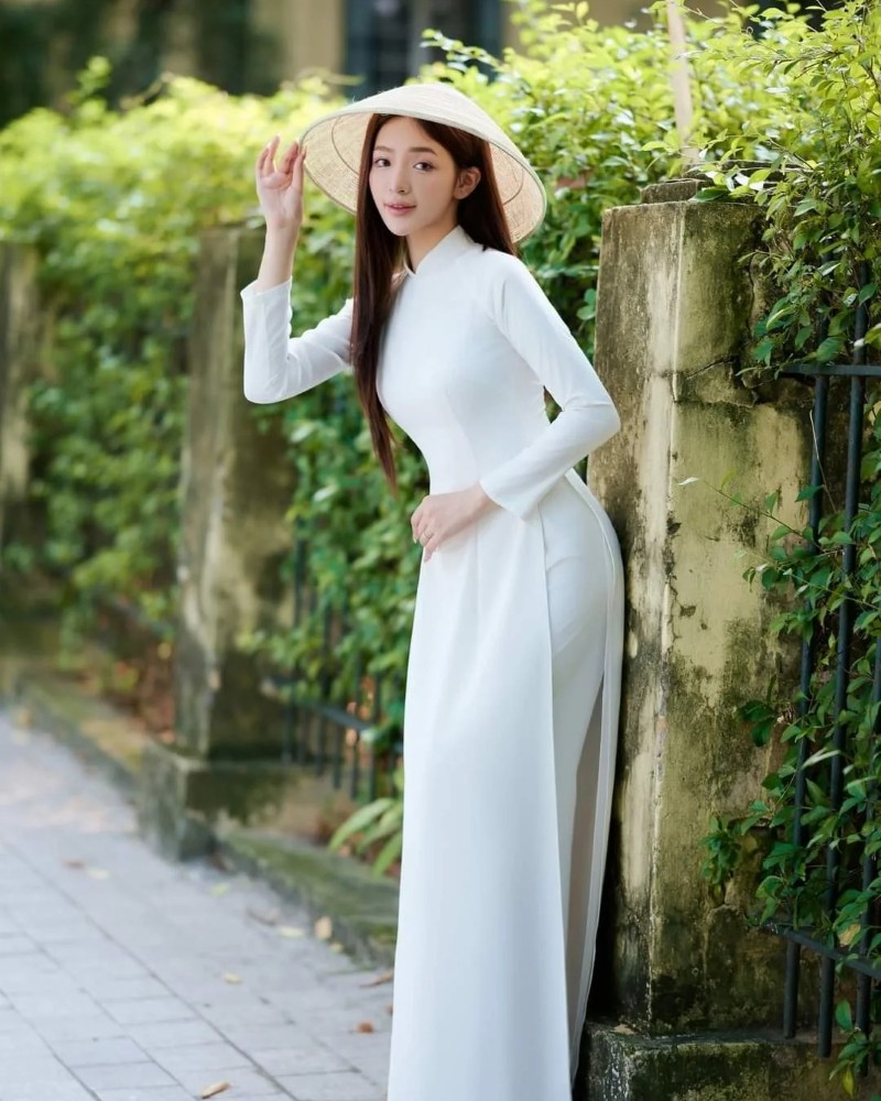 Cô gái mặc áo dài trắng đứng giữa con hẻm xanh