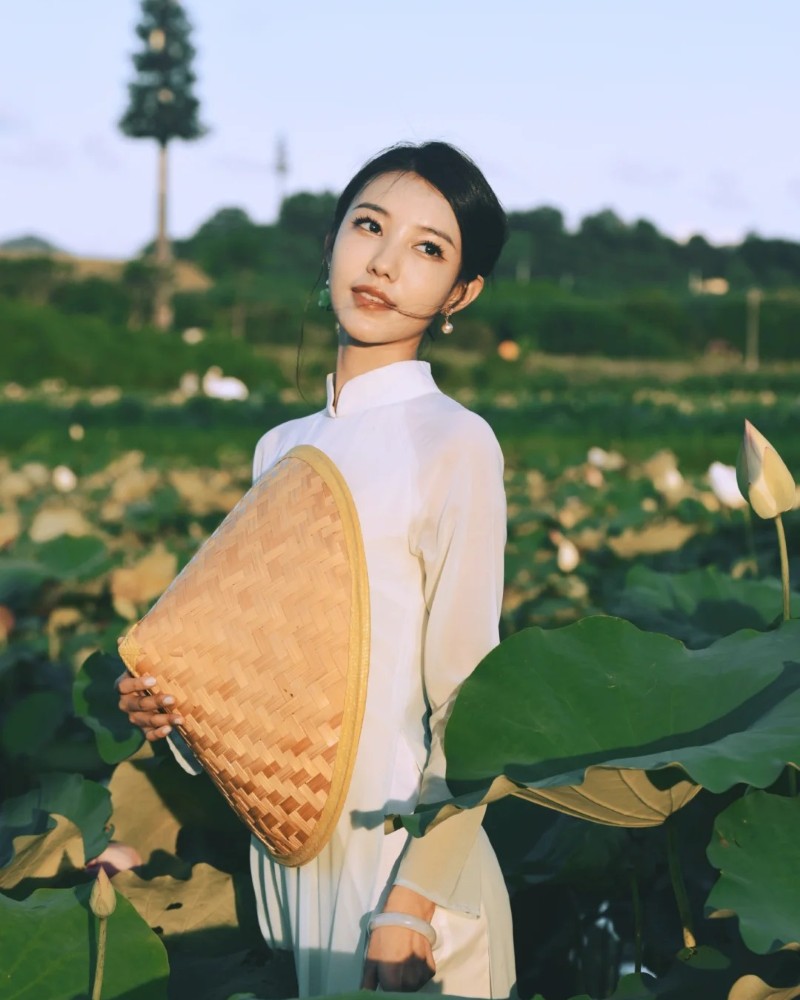 Người đẹp khoác áo dài trắng chụp ảnh trong vườn