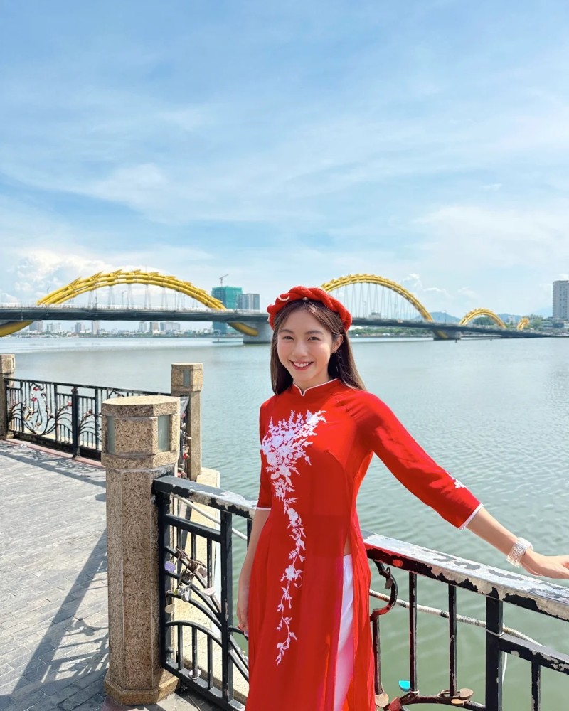 Cô gái diện áo dài đỏ tạo dáng bên lan can