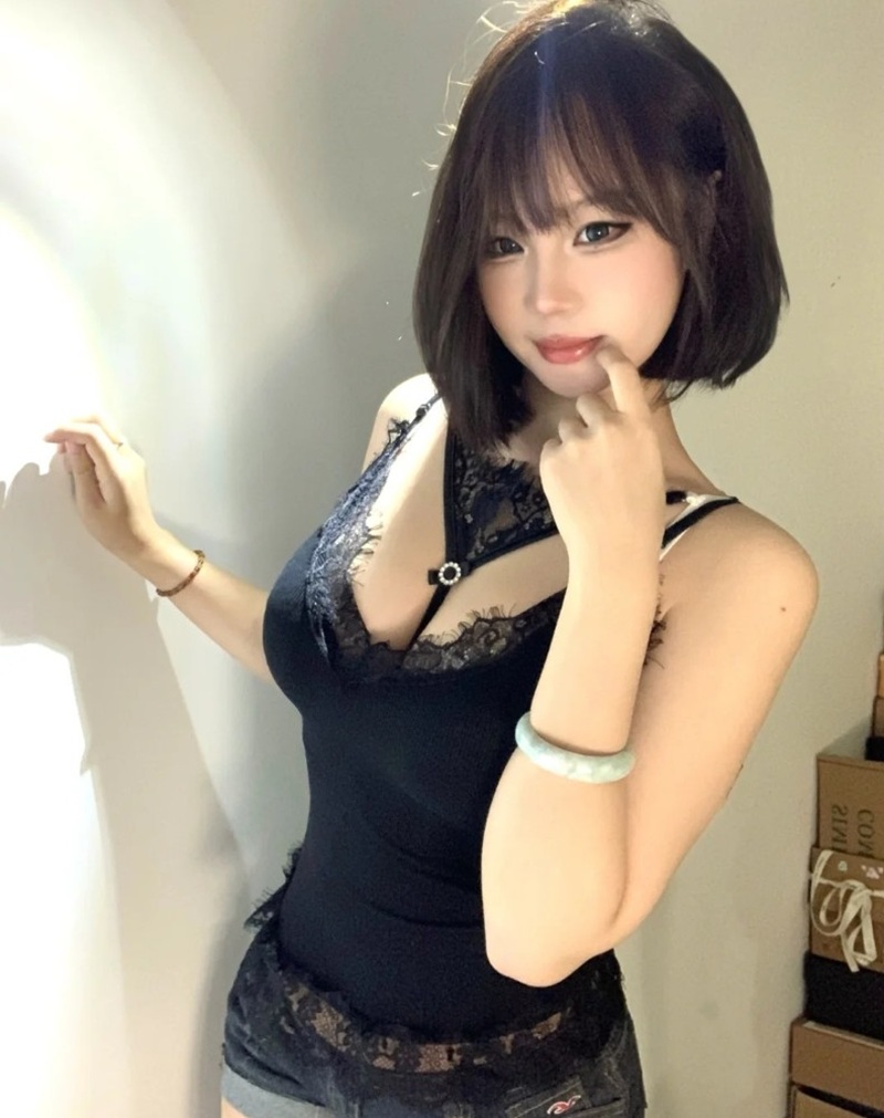 ảnh cô gái mặc váy đen ôm sát tạo dáng cạnh tường