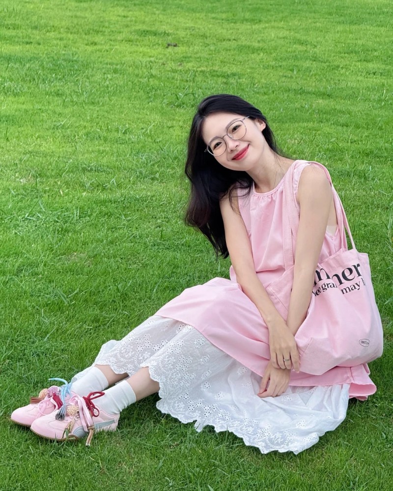 cô gái mặc váy pinky ngồi trên thảm cỏ