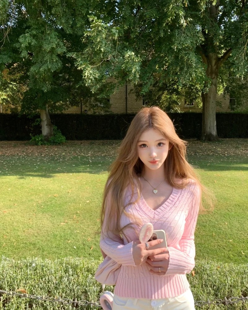 gái xinh mặc váy pinky ngồi trên bãi cỏ