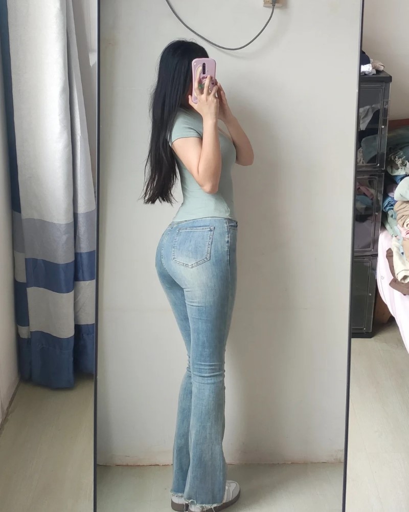 Người đẹp mặc quần bó sát đứng trước gương