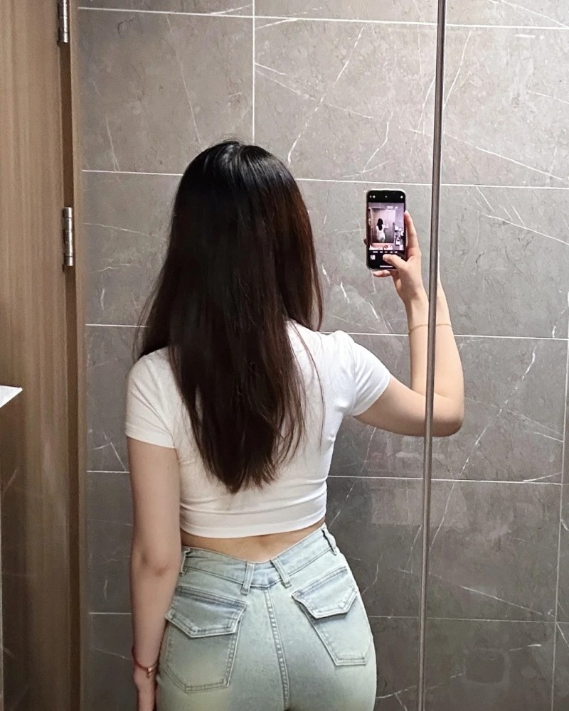 Cô gái đứng bên cửa kính khoe dáng thon