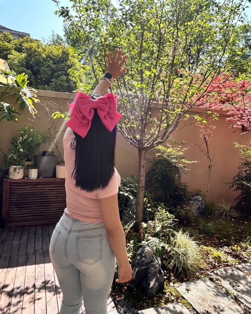 Cô gái trẻ quay lưng ngoài nắng khoe vòng ba đẹp