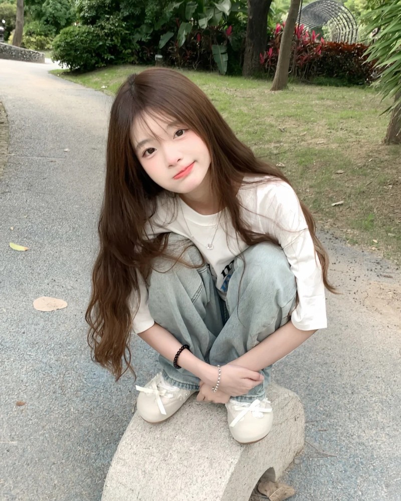 cô gái ngồi dưới nắng nhẹ ngoài sân