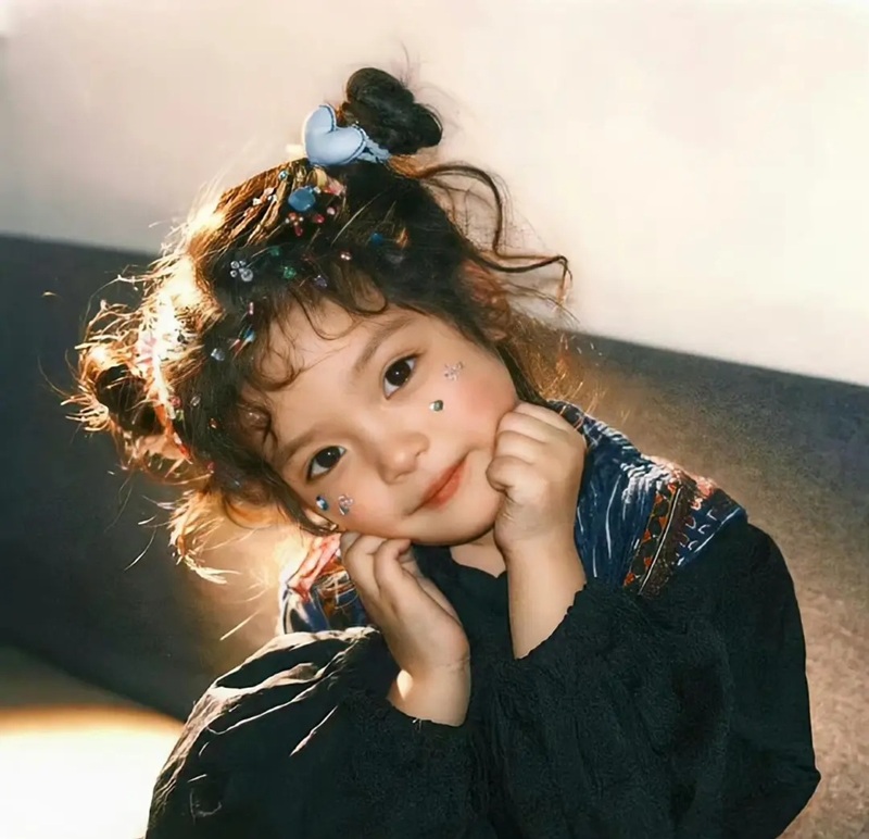 bé gái tóc xoăn pose dưới nắng