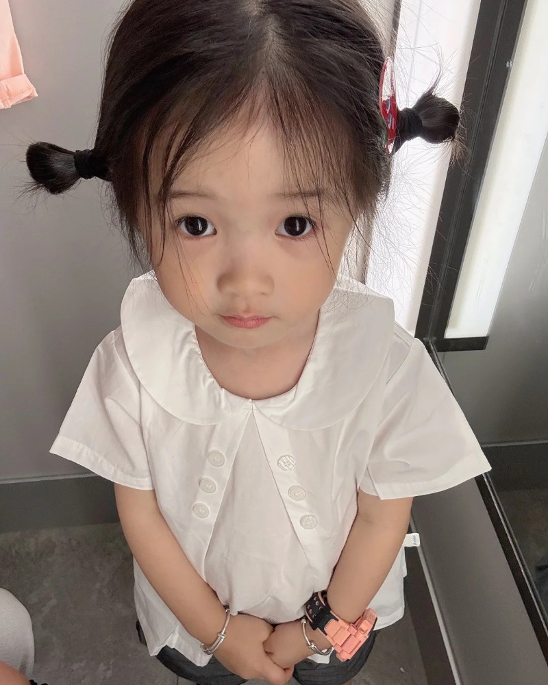 bé gái cười trong bộ đồ trắng đơn giản