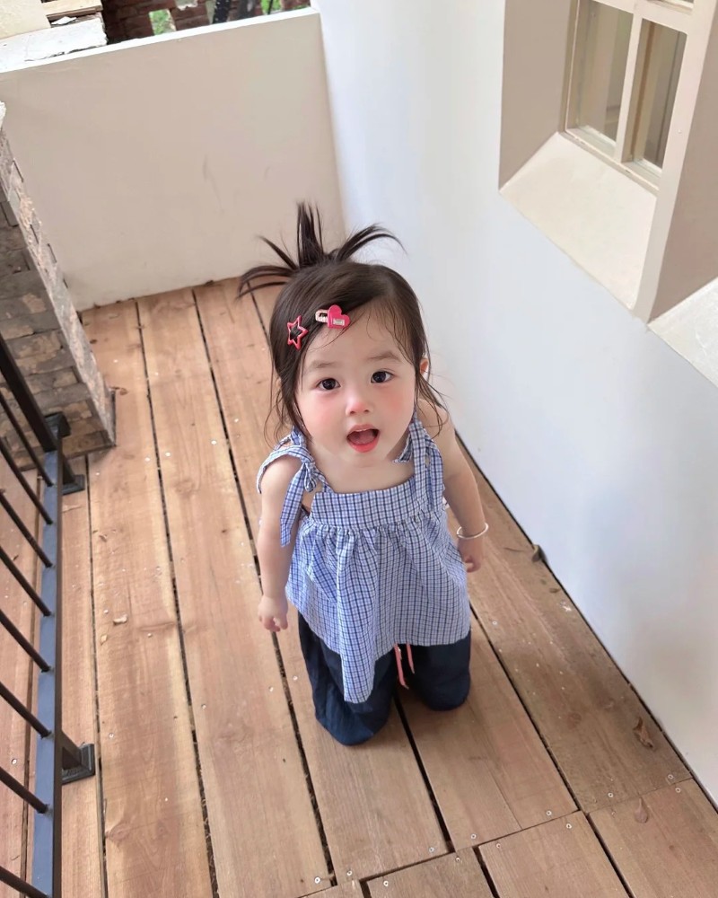 bé gái đứng trước cửa phòng tạo dáng