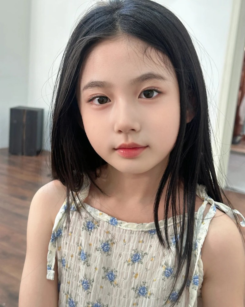 bé gái nhìn ống kính với biểu cảm dễ thương