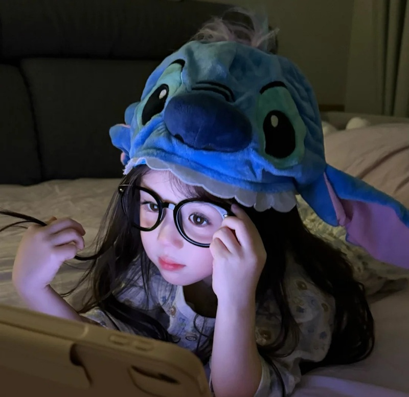 bé gái đội mũ thú xanh cười tươi