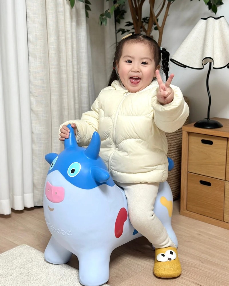 bé gái cười tươi ôm thú nhún 