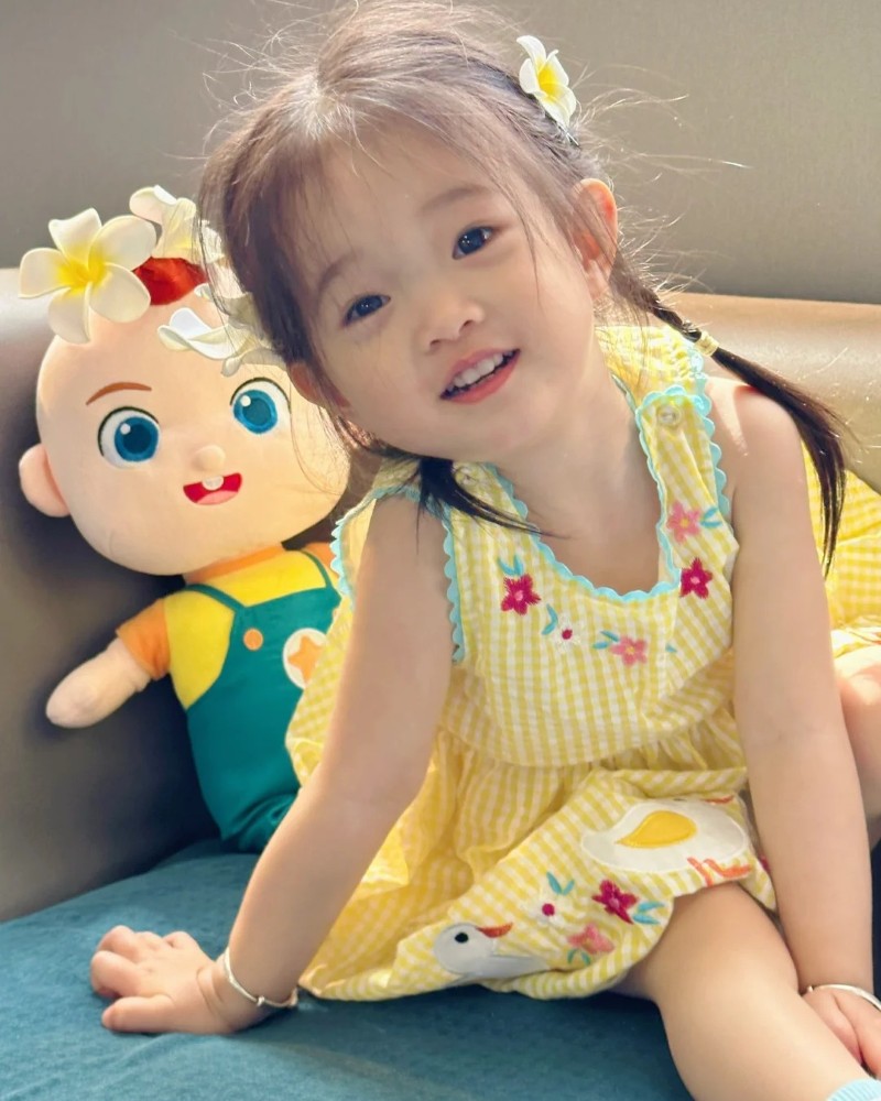 bé gái mặc áo vàng pose nhẹ