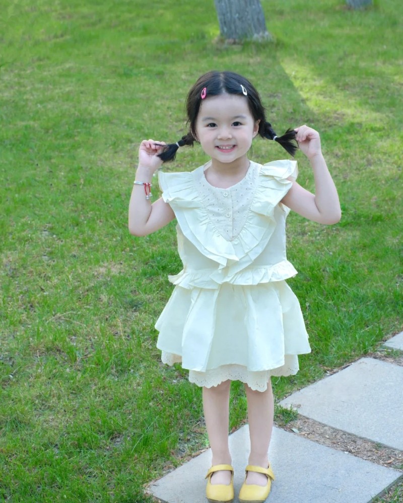 bé gái dang tay cười tươi ngoài trời