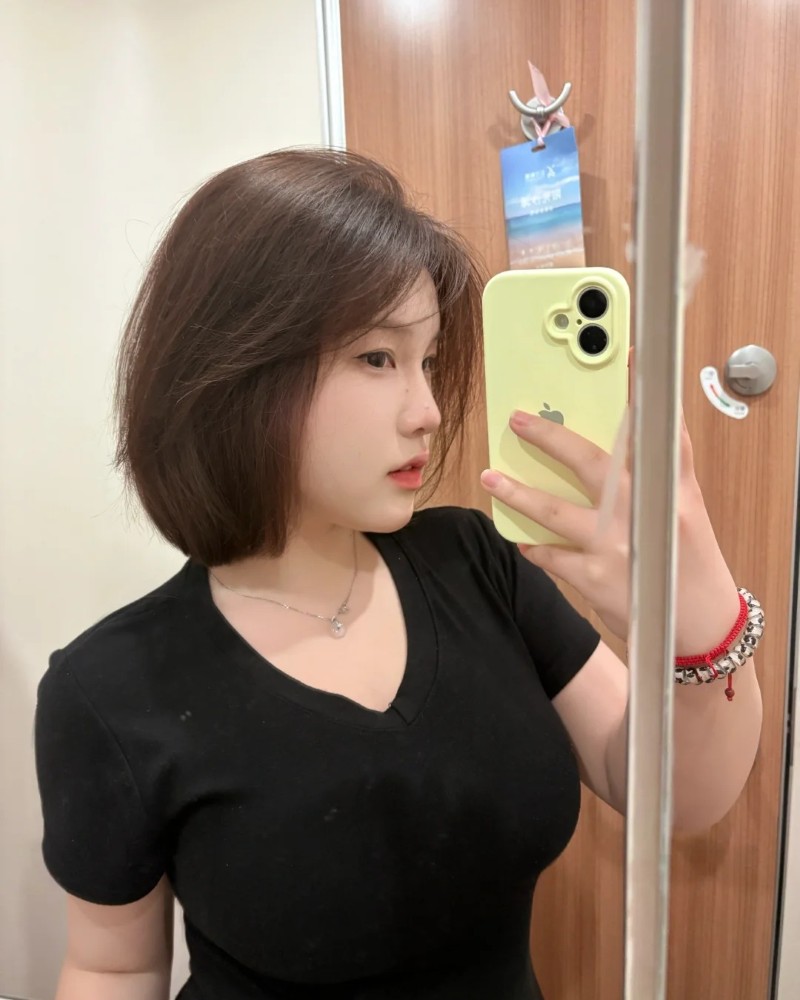 cô gái tóc bob chụp ảnh trước gương phòng ngủ