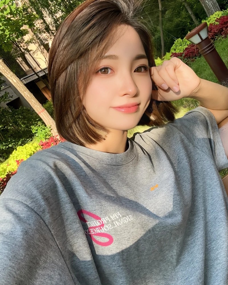 bạn nữ tóc ngắn cười tươi dưới tán cây