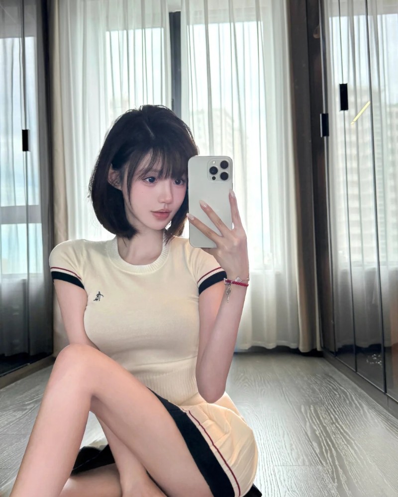 cô gái tóc ngắn tạo dáng trong phòng màu trắng