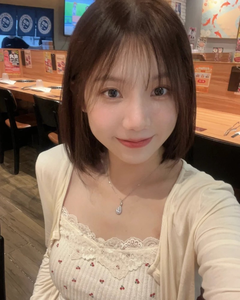 bạn nữ tóc ngắn cười nhẹ trong quán cà phê