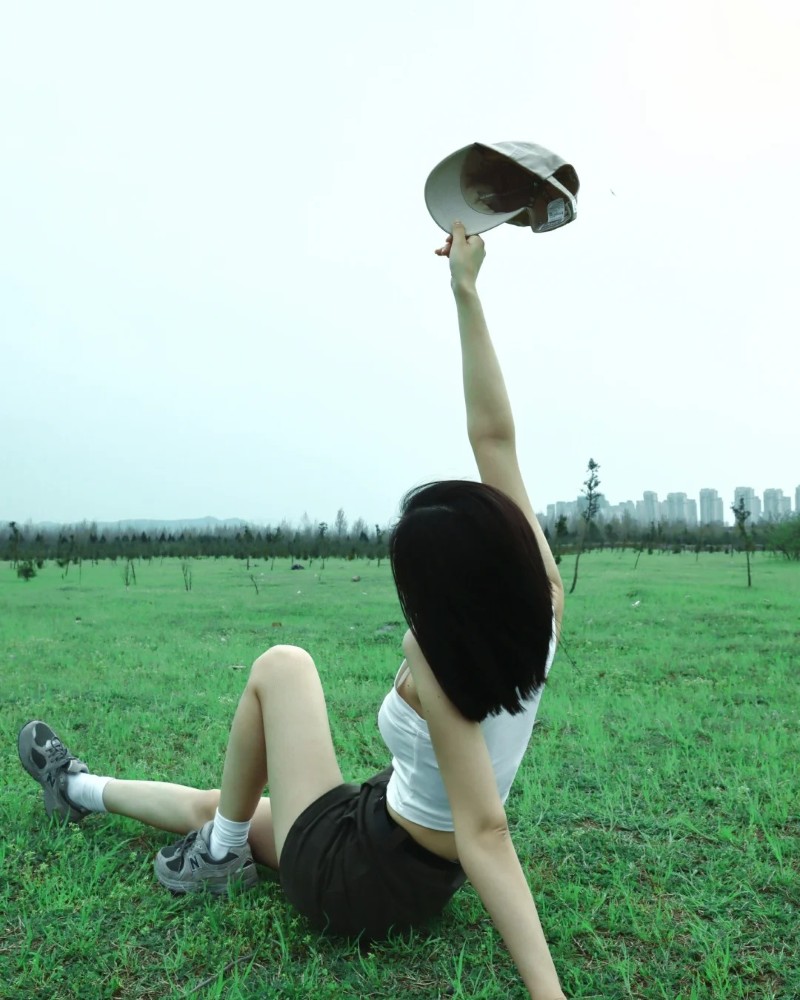 Hình gái đẹp tóc ngắn nằm trên cỏ tạo dáng