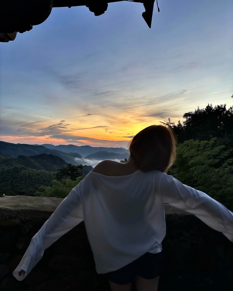 cô gái tóc ngắn đứng bên hồ lúc hoàng hôn